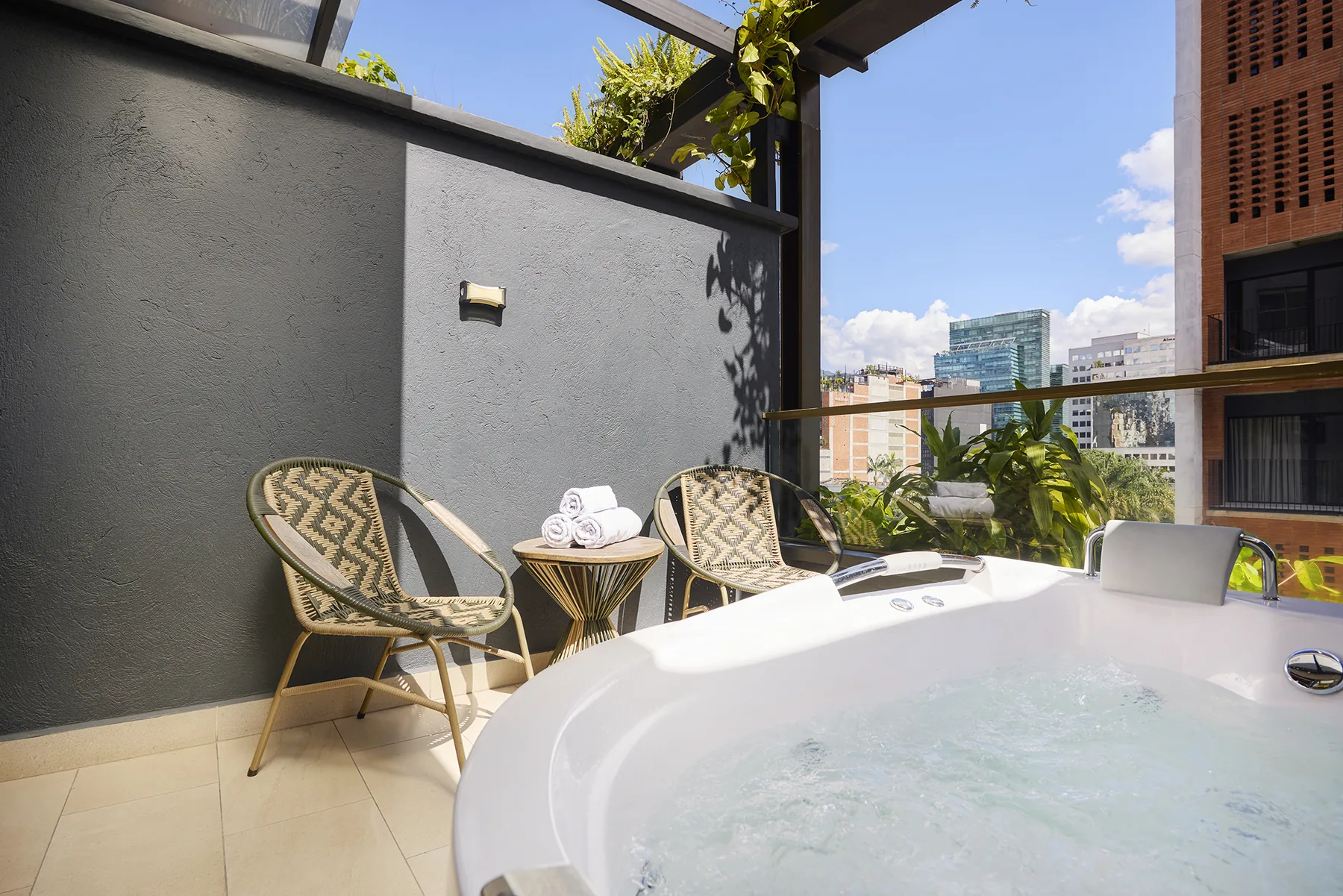 Jacuzzi en el balcón con la ciudad de fondo