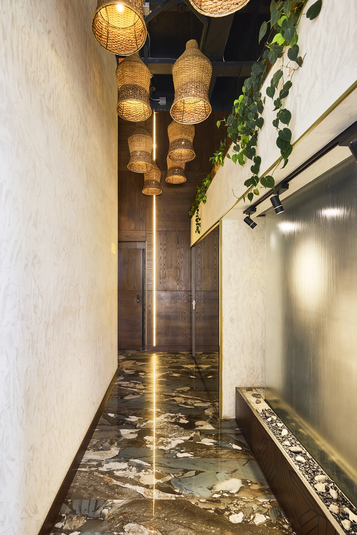 Corredor de entrada de Golden Valley Hotel con lámparas de mimbre y detalles en latón